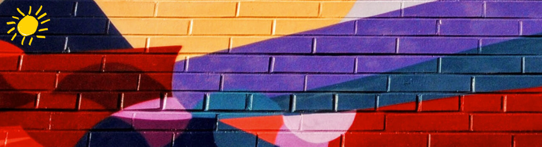 A brightly painted brick wall with abstract shapes in shades of red, yellow, purple, and blue
