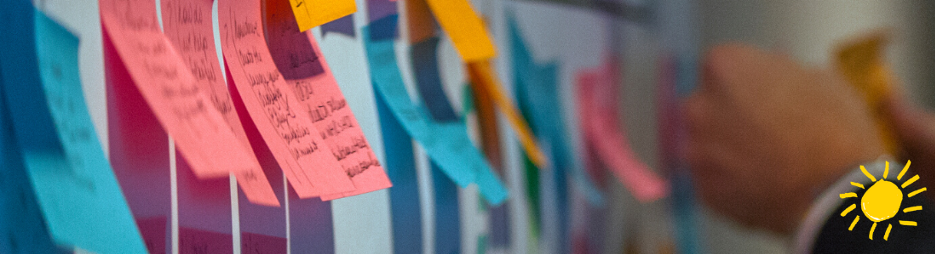 Brightly-colored post-its appear on a blue wall
