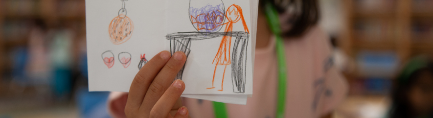 Close-up of child's drawing of girl at table holding bowl
