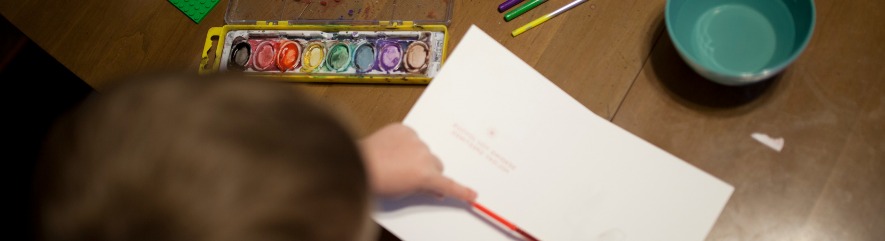 Tabletop view of kid using art supplies