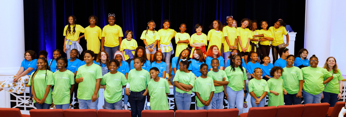 theatre students line up in three rows wearing three different brightly color t-shirts - green, yellow, and blue