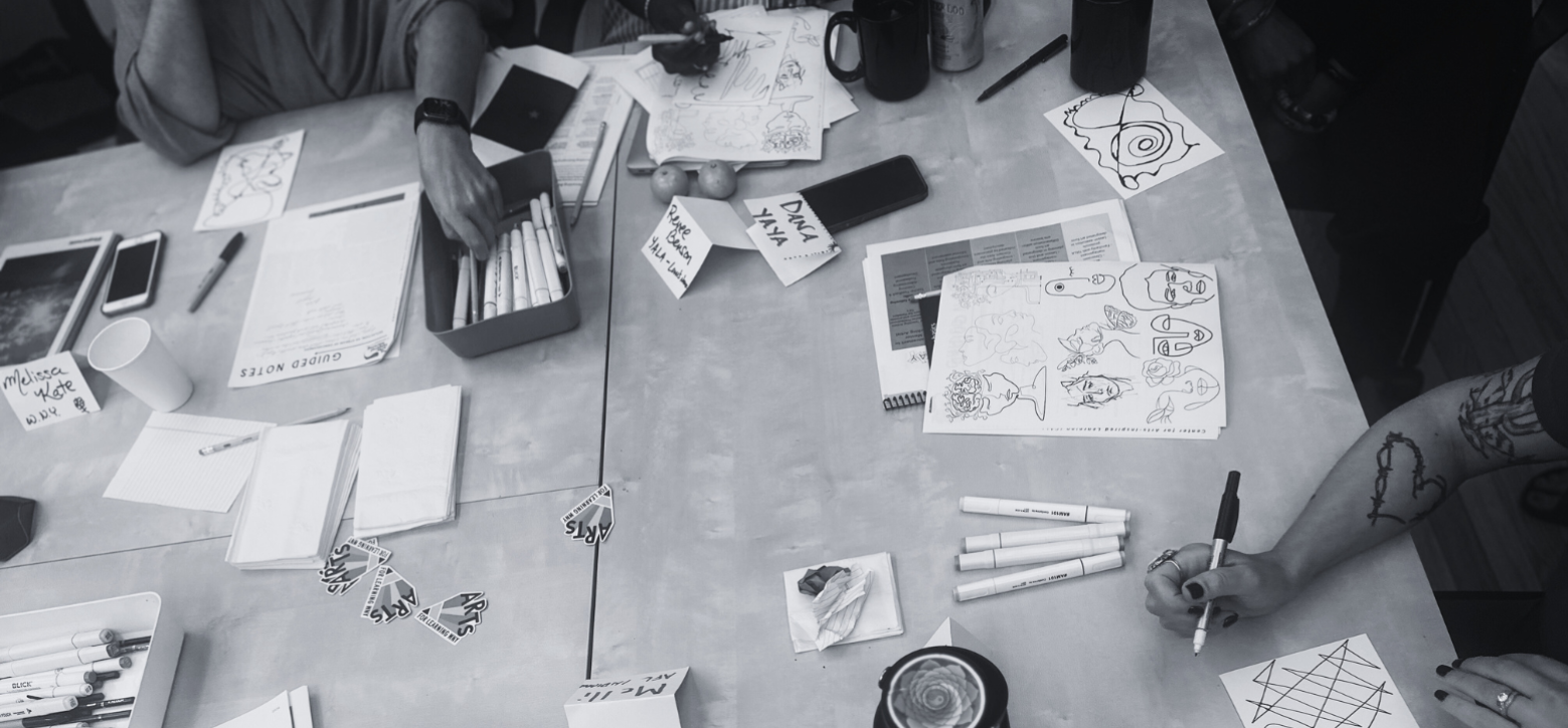 Black and white photo overlooking art-making activities on table